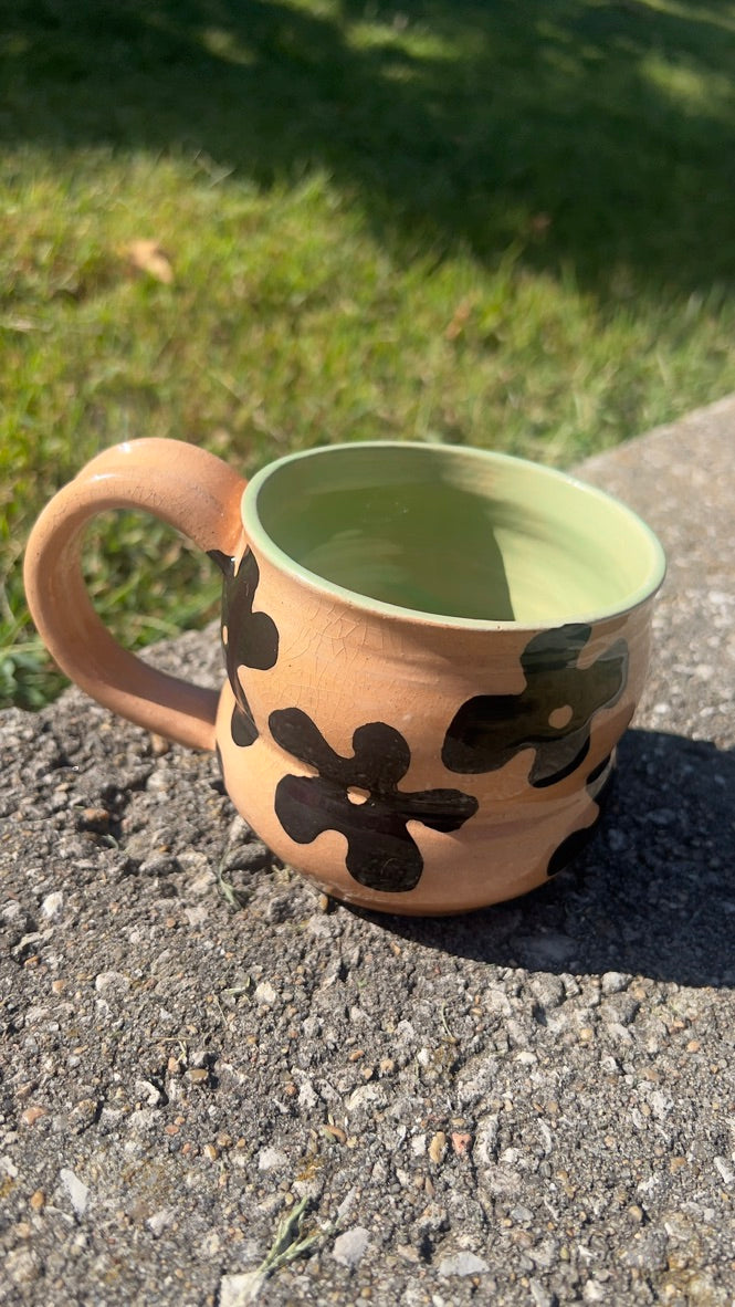 Ceramic mug with floral patterns on a concrete surface