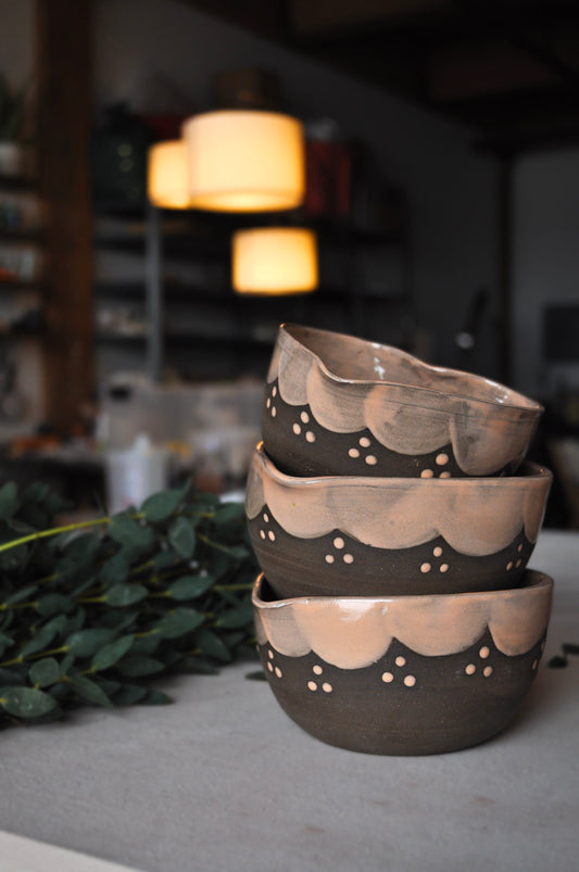 Stack of ceramic bowls with decorative patterns on a blurred background