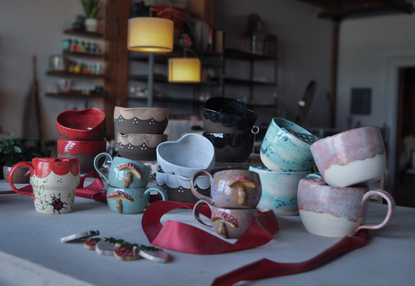 Collection of ceramic mugs and bowls on a table with a blurred background