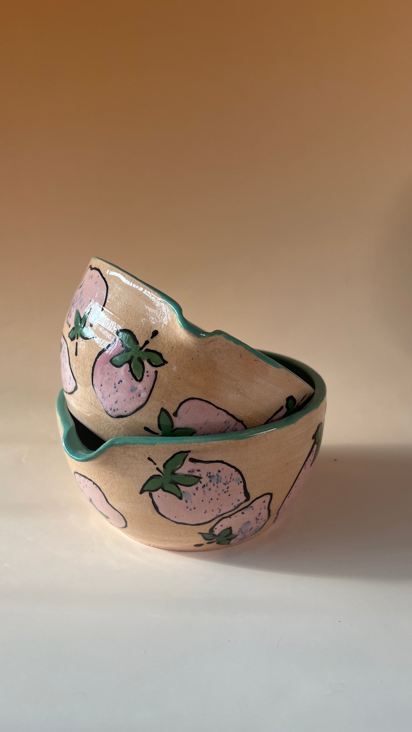 Ceramic bowl with pink strawberries design on a beige background