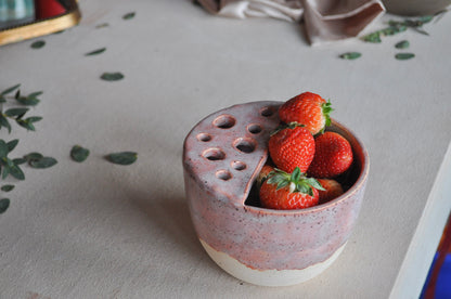 Ceramic container with strawberries on a textured surface