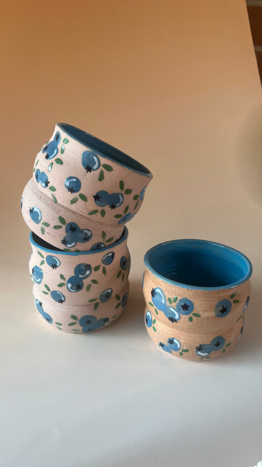 Set of ceramic bowls with blueberry patterns on a plain background