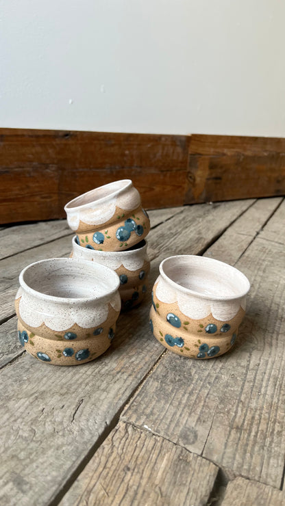 Set of ceramic pots with decorative patterns on a wooden surface