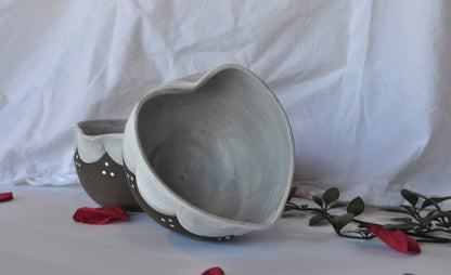 Two gray ceramic bowls on a white surface with a white background