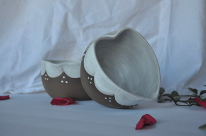 Two ceramic bowls on a white surface with a white curtain background