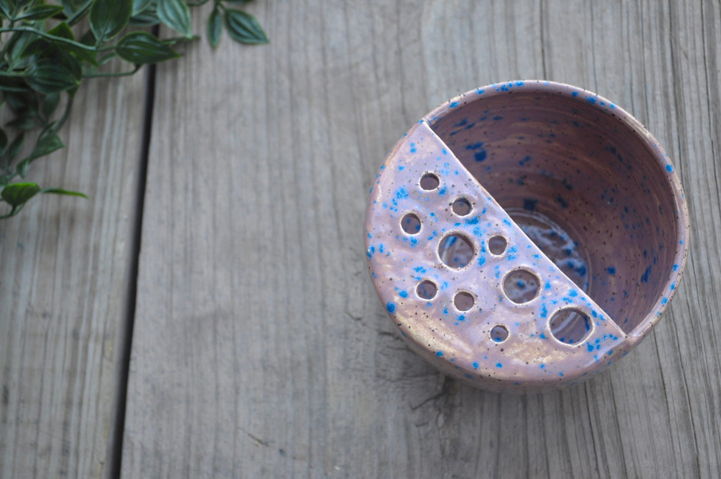 Ceramic bowl with blue speckles on a wooden surface