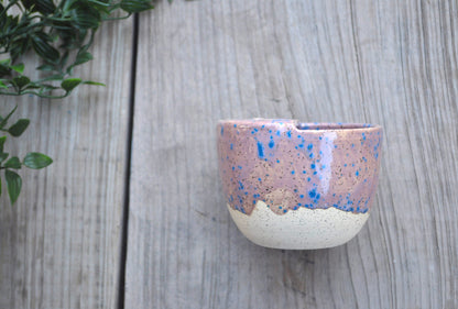 Ceramic cup with speckled design on a wooden surface