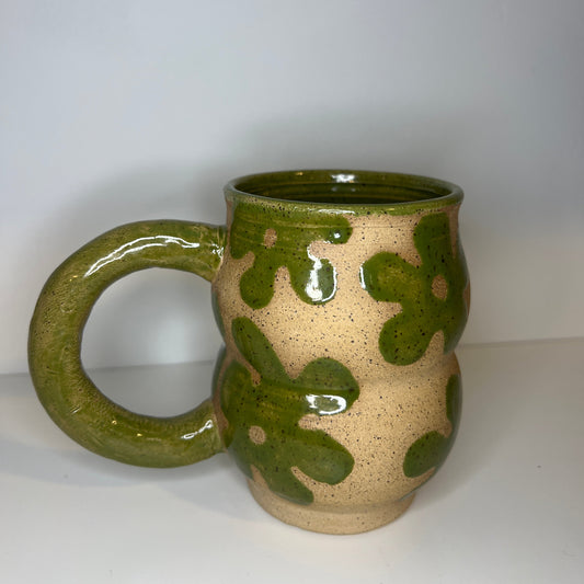 Ceramic mug with green and beige design on a white background