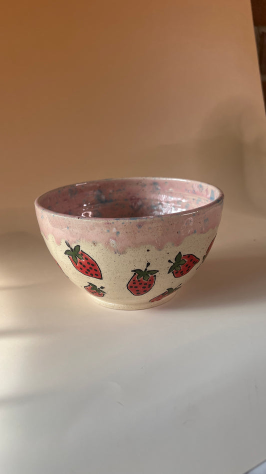 Ceramic bowl with strawberry patterns on a plain background
