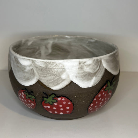 Dark brown ceramic bowl with strawberry designs and added with a red inside and The red rim features a hand-glazed swooping design that adds movement and visual interest. The bowl is against a white background