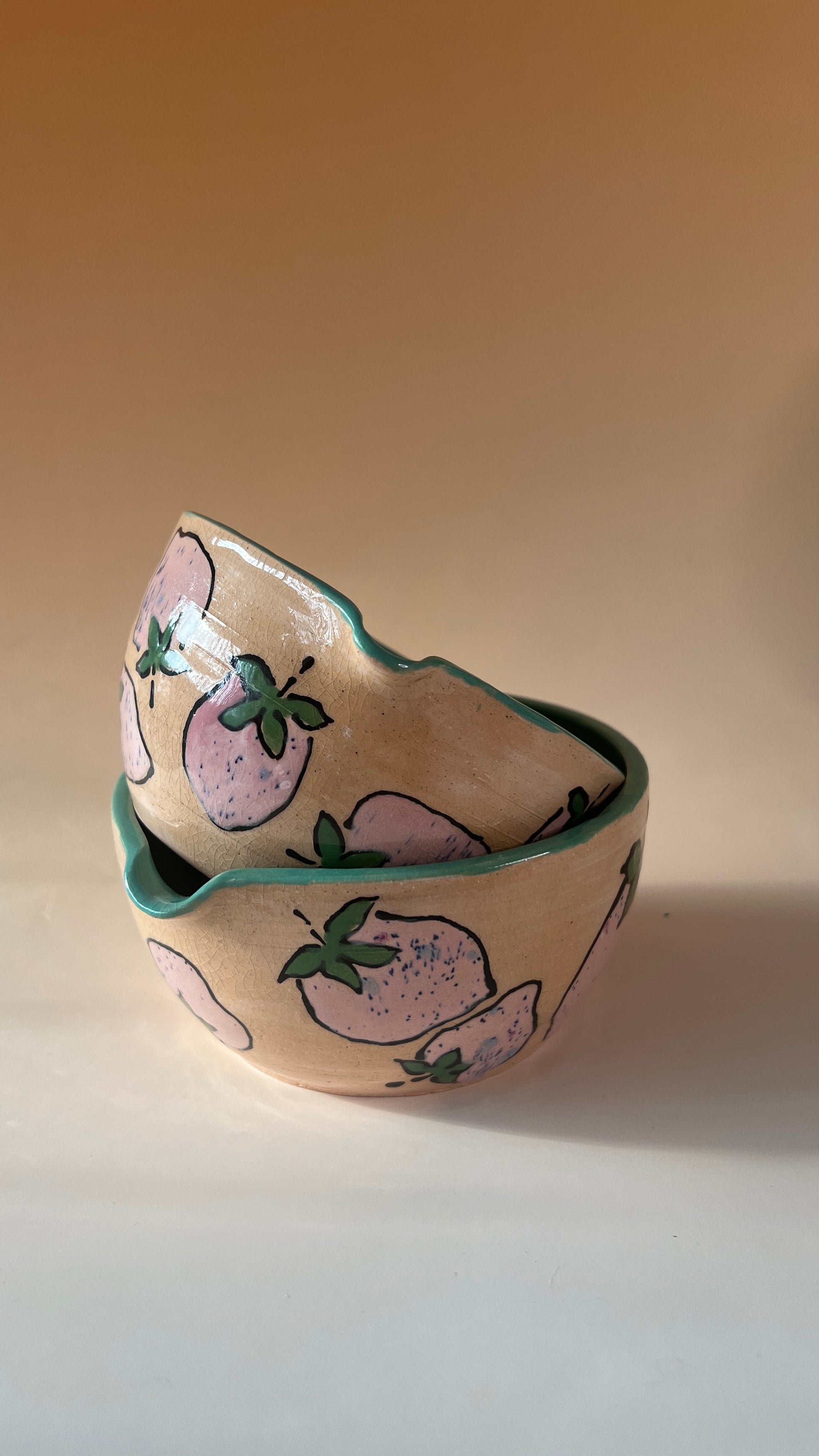 Ceramic bowl with pink strawberries design on a beige background