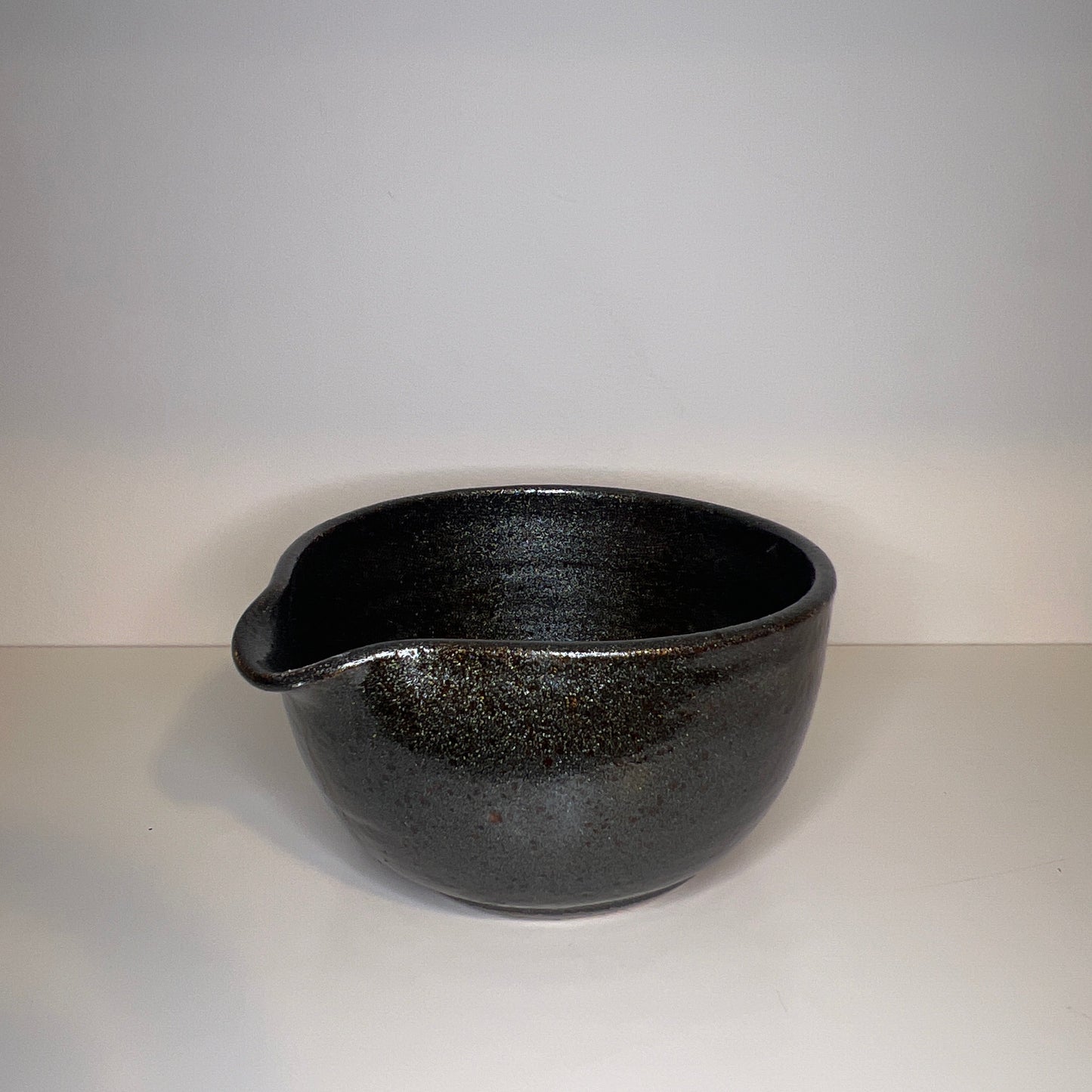 Black ceramic bowl on a light gray background