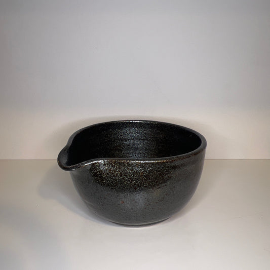 Black ceramic bowl on a light gray background